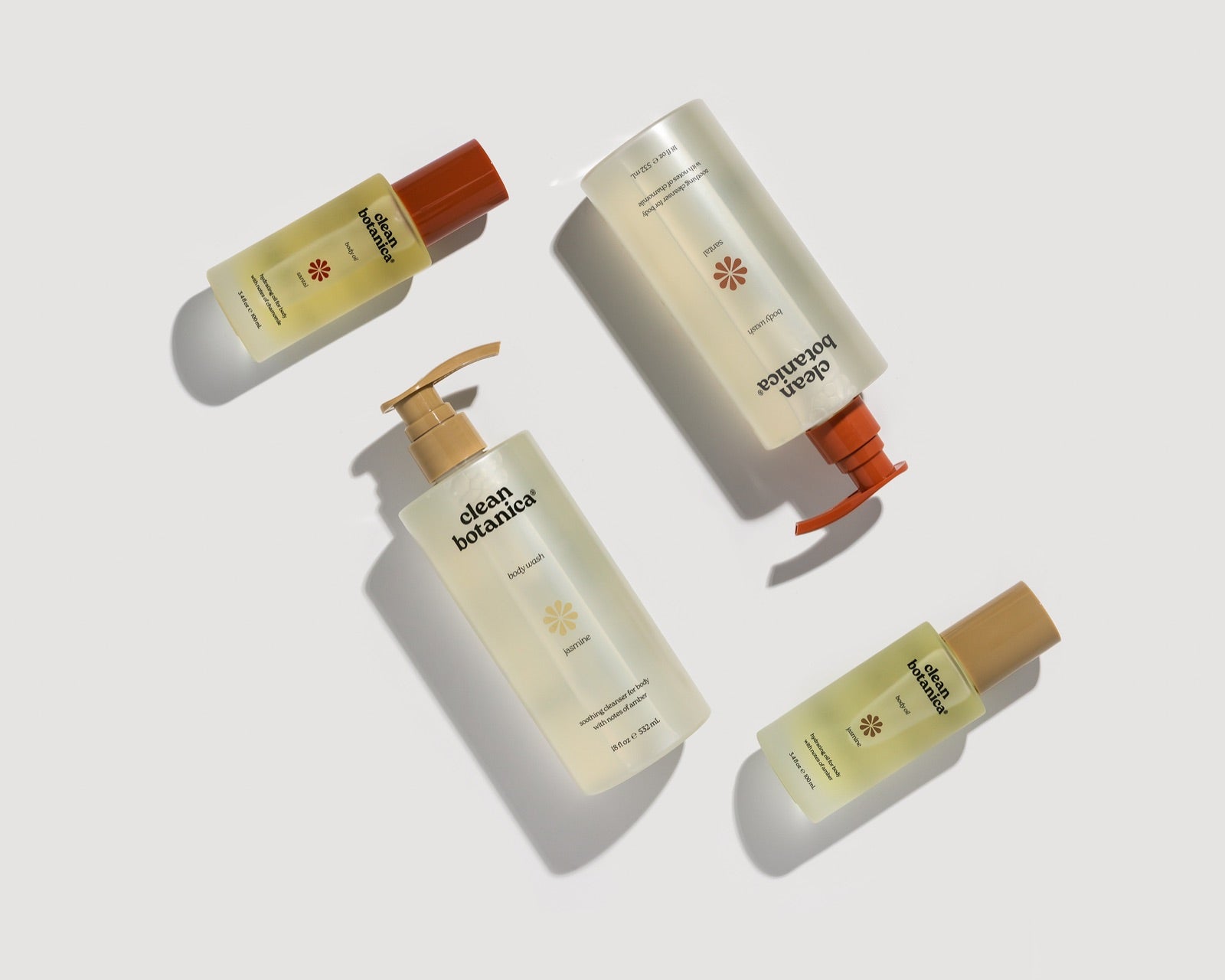 Clean Botanica body washes and body oils laid flat on white